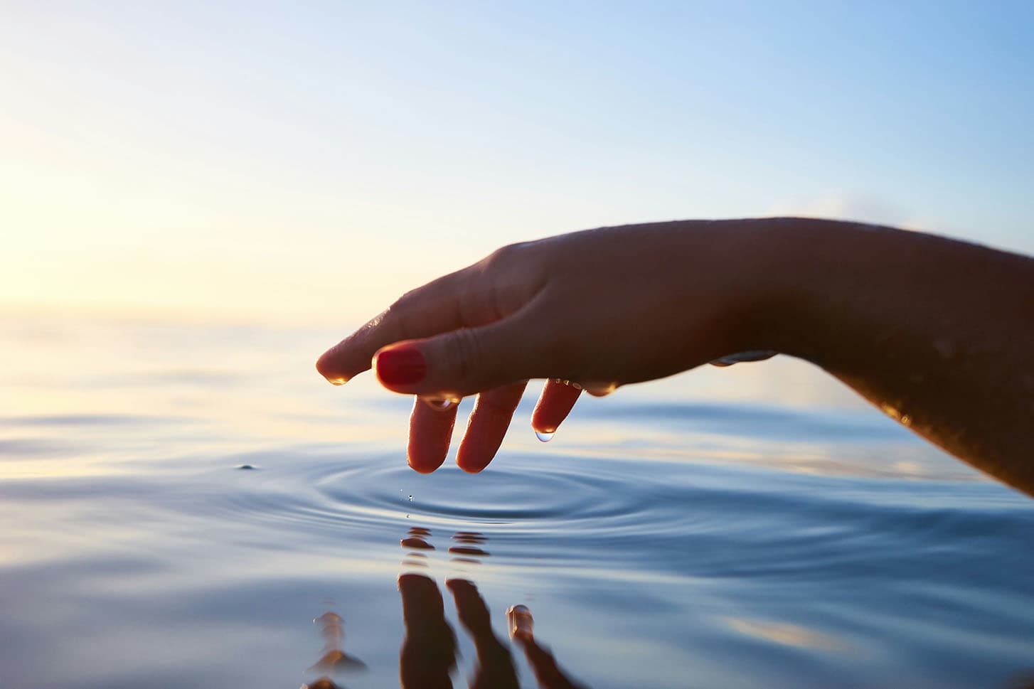 Hand over water with water droplets